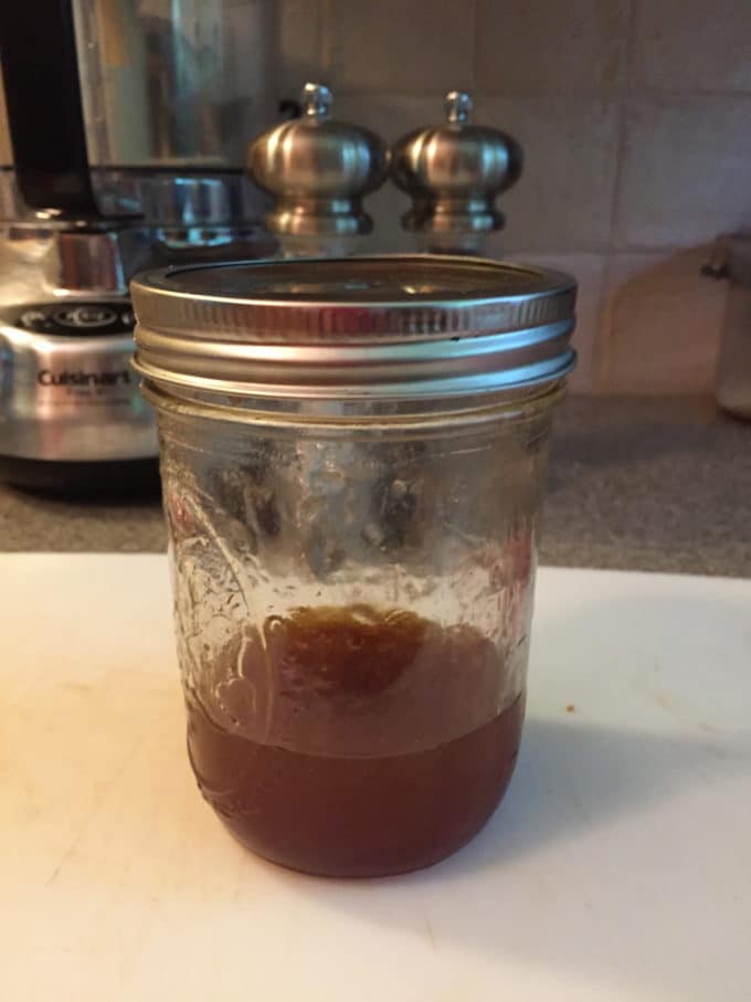 A mason jar full of salad dressing.