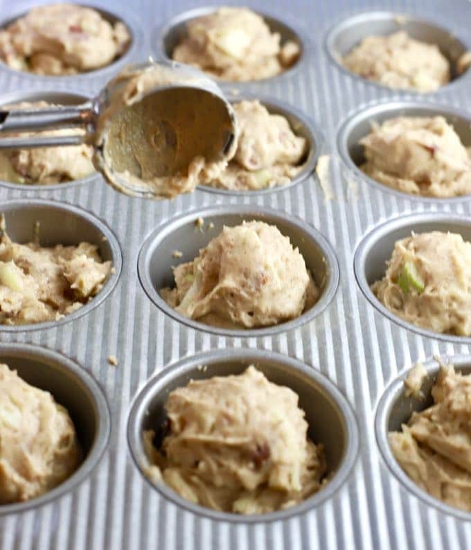 Using an ice cream scoop to fill muffin cups for Easy Apple Cranberry Muffins