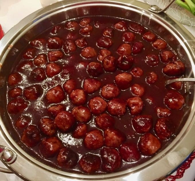 Glazed turkey meatballs with grape jelly and chili sauce in a chafing dish.