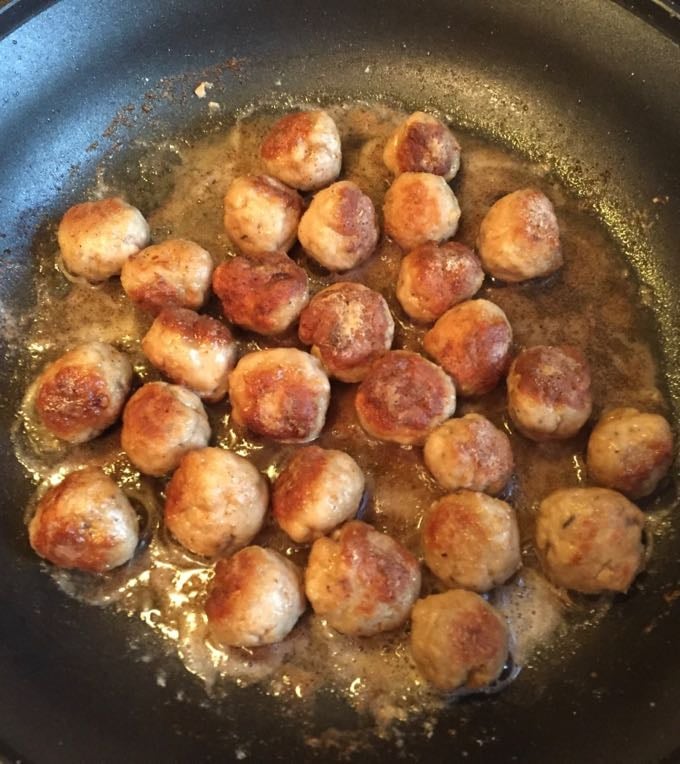 Frying turkey meatballs in a skillet.