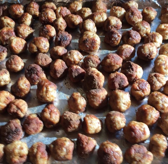 Cooked meatballs on a baking sheet.