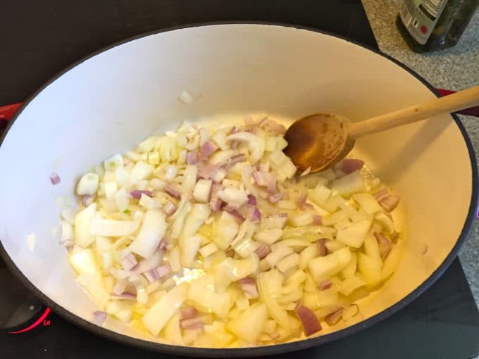 Cooking onions and shallots in a large dutch oven.
