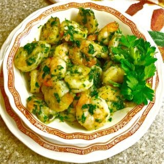 Spicy Shrimp in Green Sauce in a white bowl and garnished with parsley