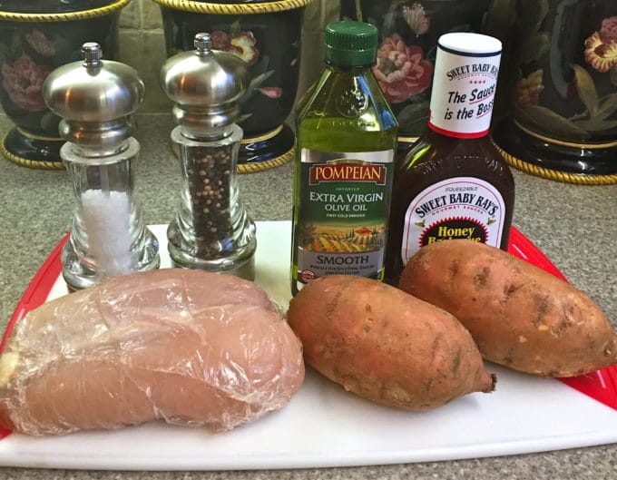 Chicken breasts, sweet potatoes, olive oil, BBQ sauce and salt, and pepper; ingredients for a chicken sheet pan dinner.