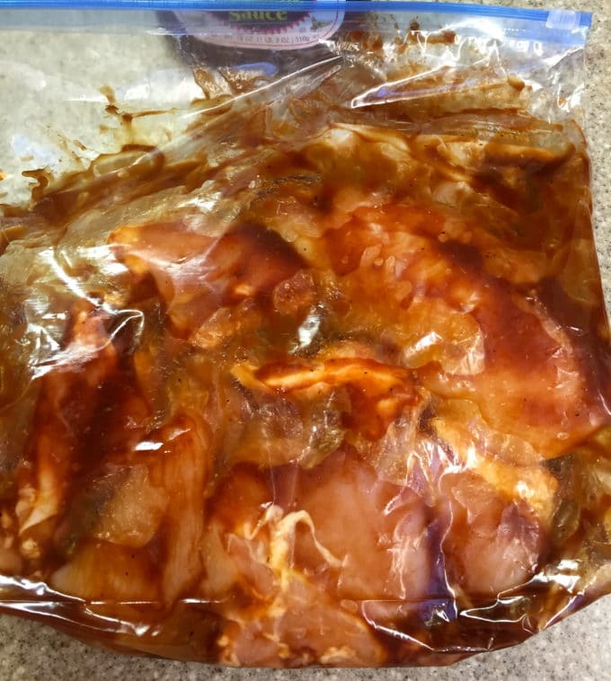 Chicken breasts in a plastic storage bag with BBQ sauce marinating.