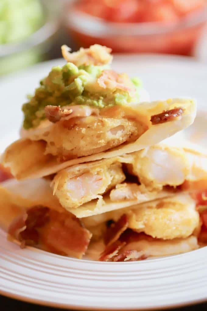 Shrimp and Bacon Quesadillas cooked and ready to eat with avocado and tomato garnish
