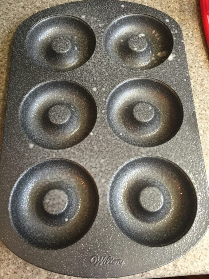 A donut baking pan which has been sprayed with non-stick baking spray.