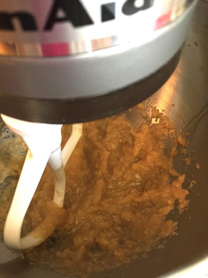 Mixing butter and sugar with an electric mixer.