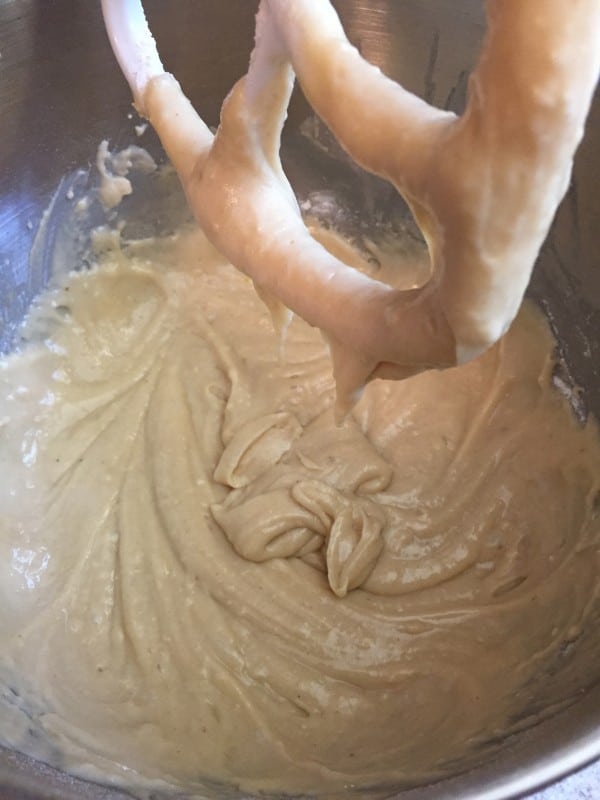 Using an electric mixer to make donut batter.