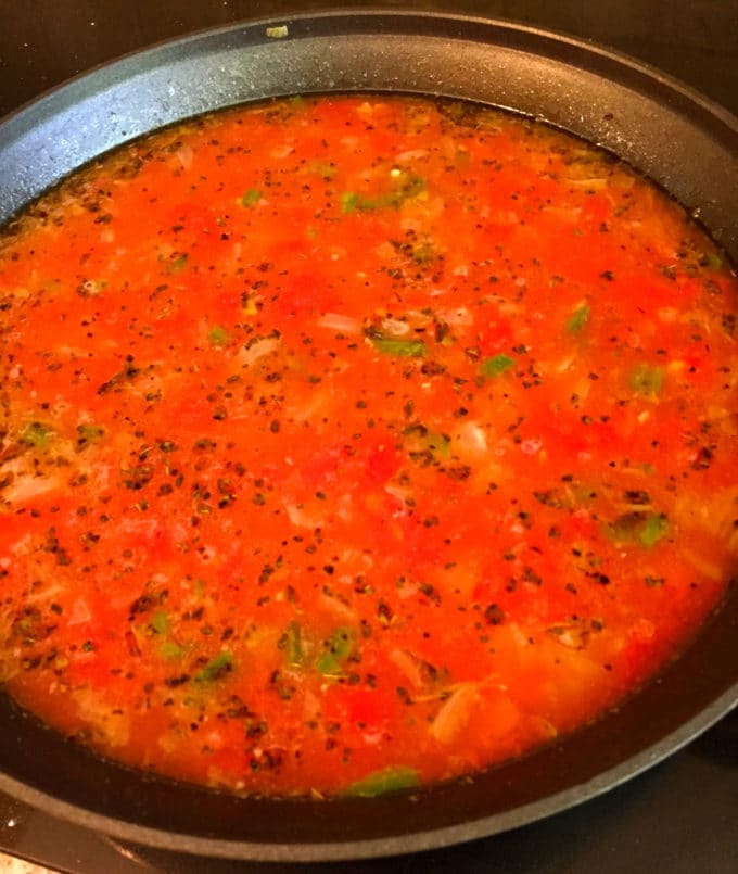Tomato tortilla soup cooking in a skillet. 