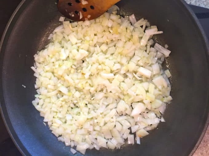 Sautéing chopped onions in a skillet for Easy Make Ahead Baked Ziti 