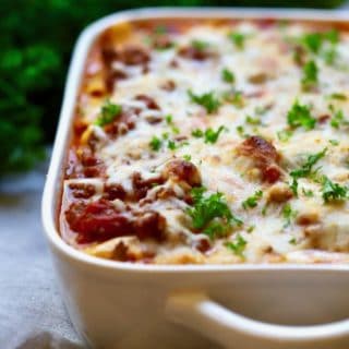 Easy Make Ahead Baked Ziti in a white baking dish garnished with fresh parsley