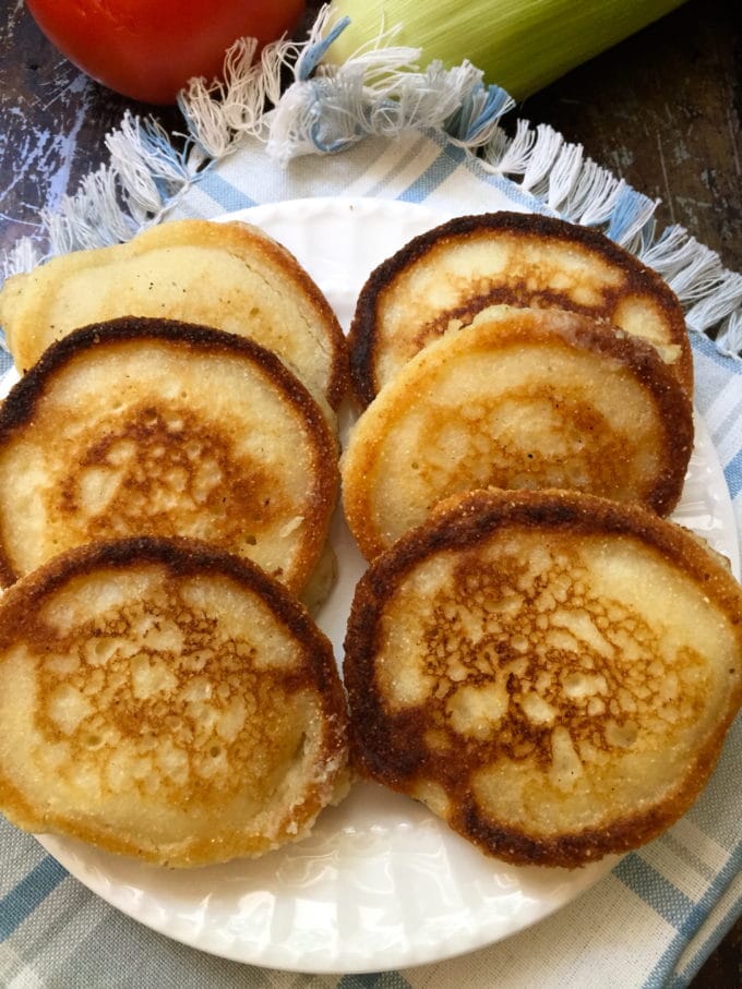 A small white plate of Hoecakes on a white and blue placemat.