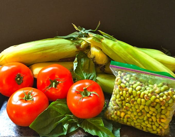 Peas in a plastic bag with fresh corn, basil, and tomatoes