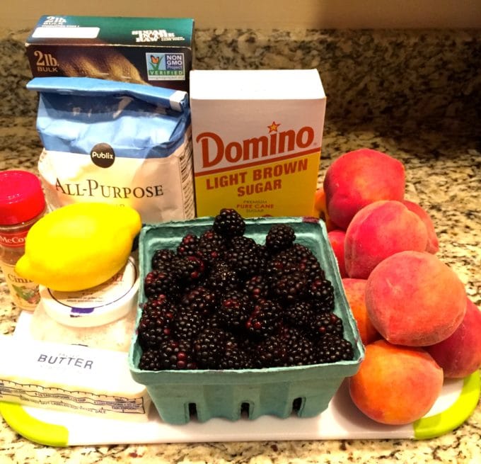 Peach and Blackberry Crumble ingredients on a cutting board including blackberries and peaches.