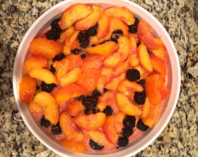 Sliced peaches with whole blackberries in a medium-size baking dish.