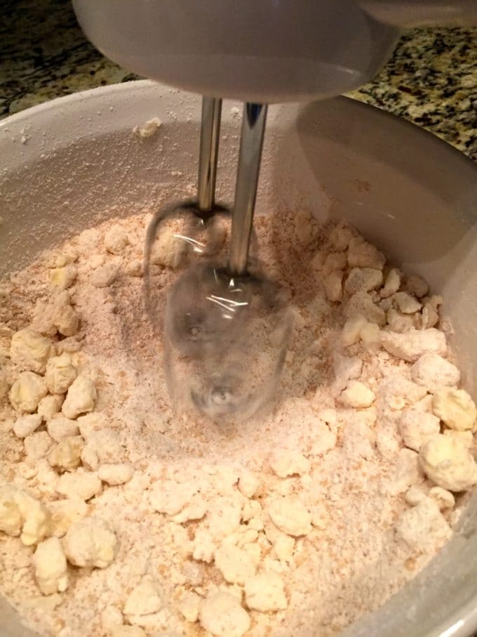 Crumble topping mixture bing mixed with an electric mixer.