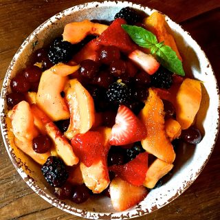 Summer Fruit Salad with Orange Syrup in a white rustic bowl.