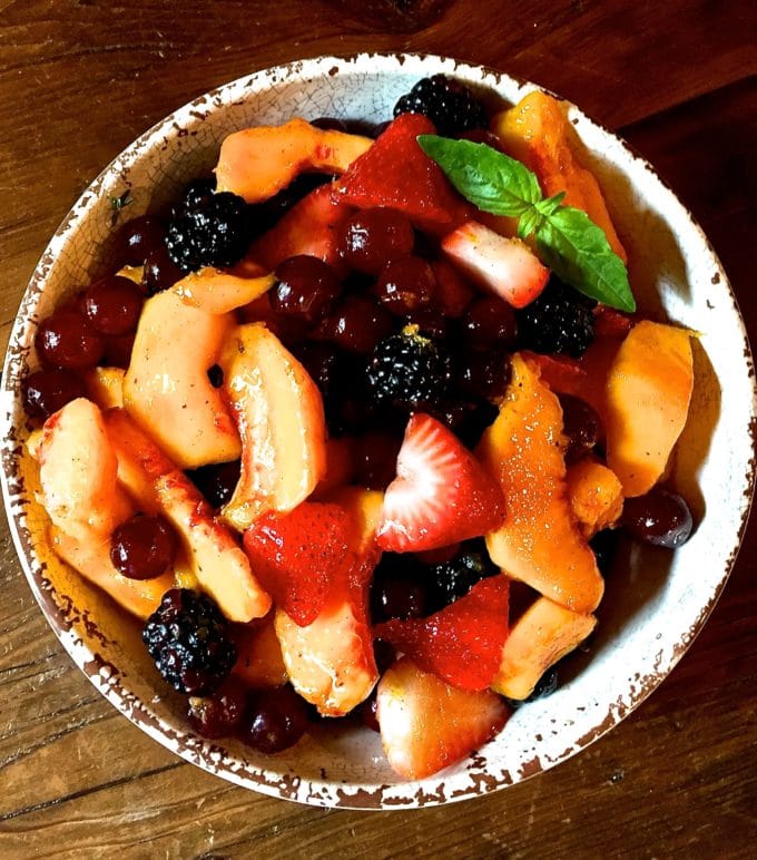 Summer Fruit Salad with Orange Syrup in a white bowl.