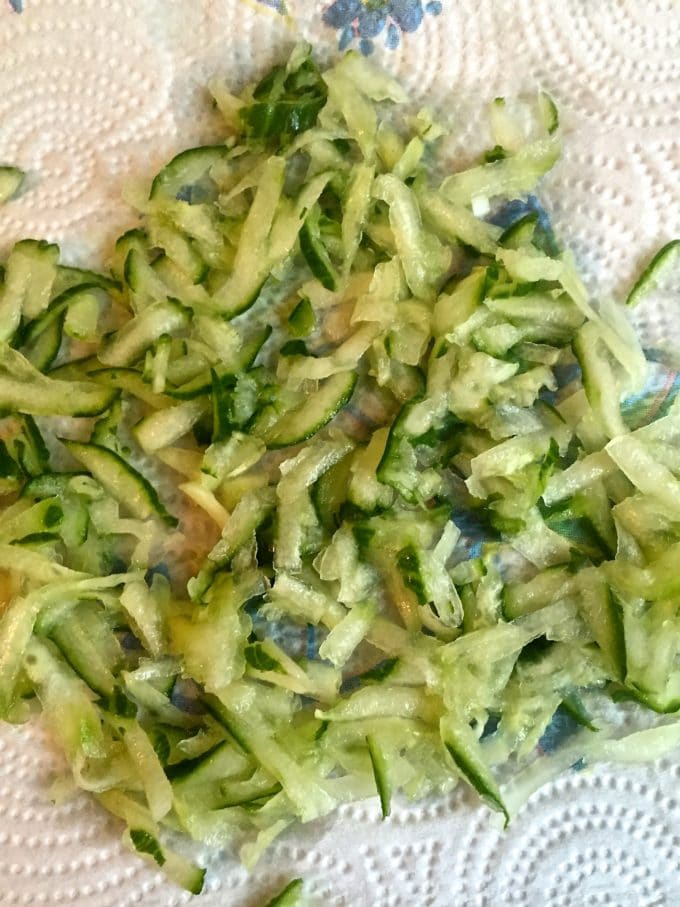 Grated cucumber draining on a paper towel.