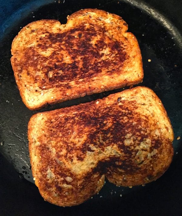 Two pieces of toast that are golden brown in a large skillet.