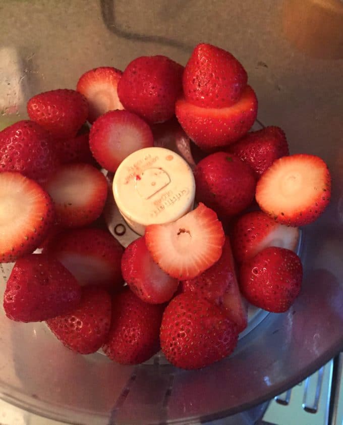 Whole strawberries in a food processor.