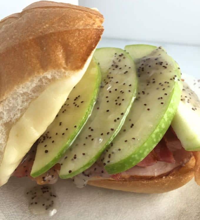 Chicken Club sandwich with sliced apples and poppyseed dressing.