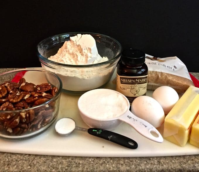 Cookie ingredients including flour and pecans on a cutting board.