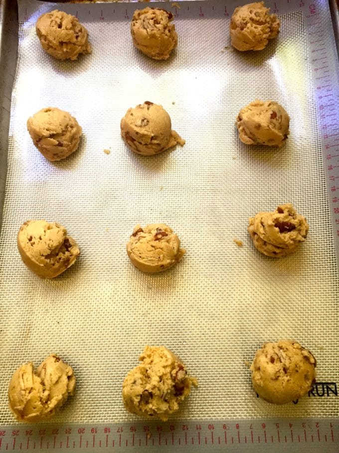 Cookie dough balls on a baking sheet ready to bake.