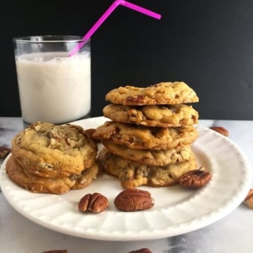 A stack of Butter Pecan Cookies on a white plate.