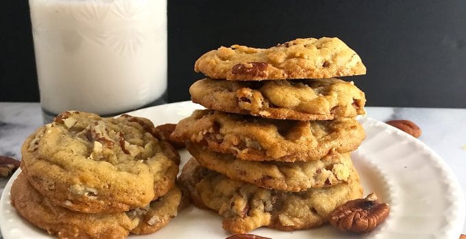 A stack of Butter Pecan Cookies on a white plate.