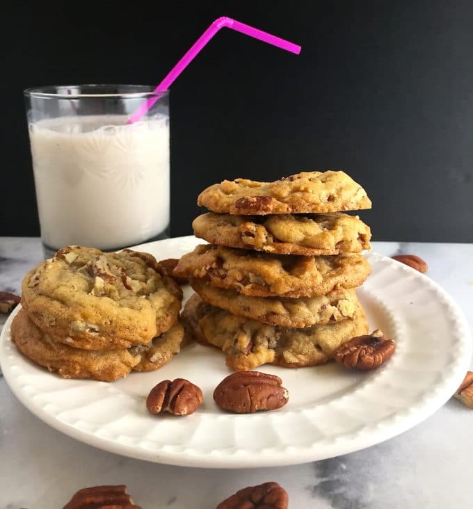 A stack of Butter Pecan Cookies with a glass of milk.