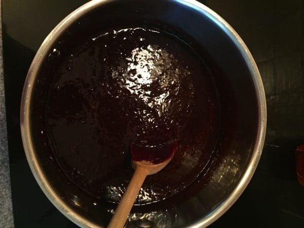 Blackberry Sauce in a medium-size saucepan with a wooden spoon.