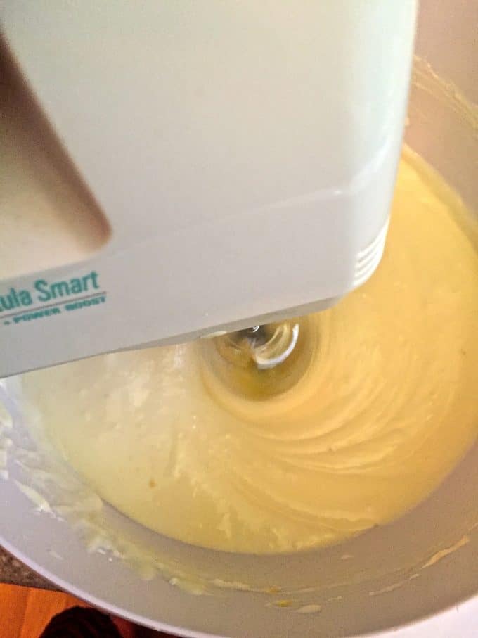  Lemon Swirl Cheesecake Batter in a large mixing bowl with an electric mixer.