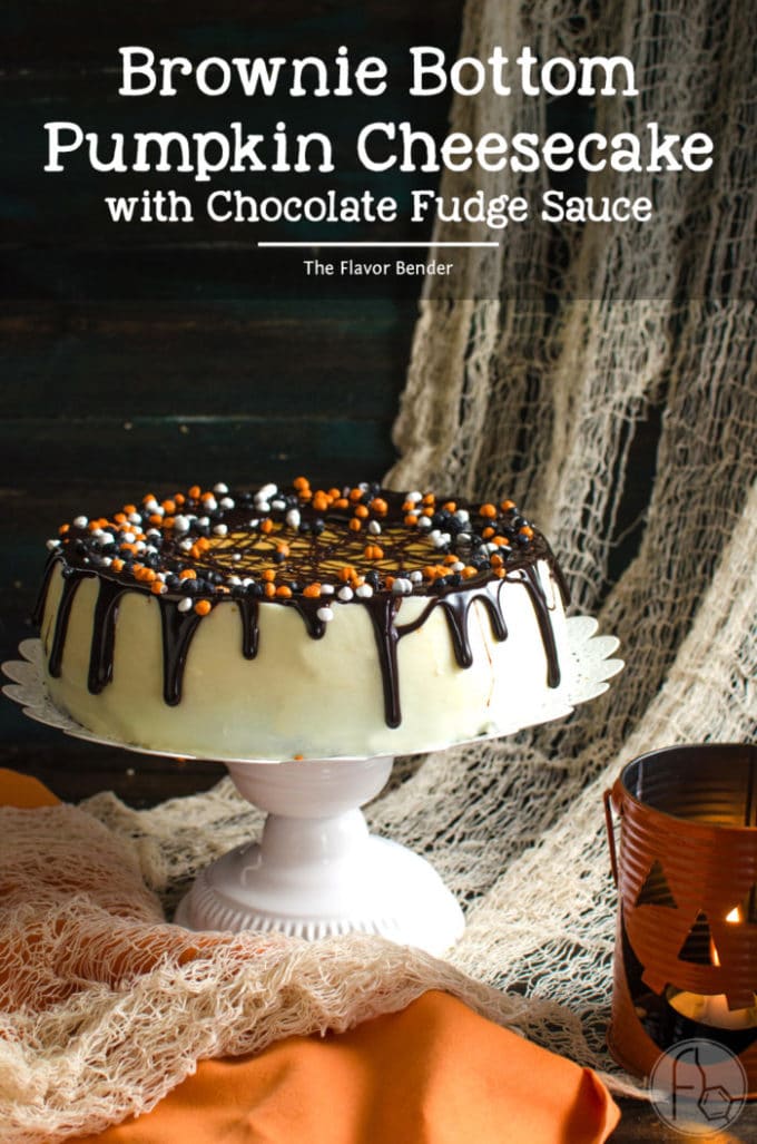 Brownie Bottom Pumpkin Cheesecake with white icing topped with chocolate and orange and black bits of candy. 