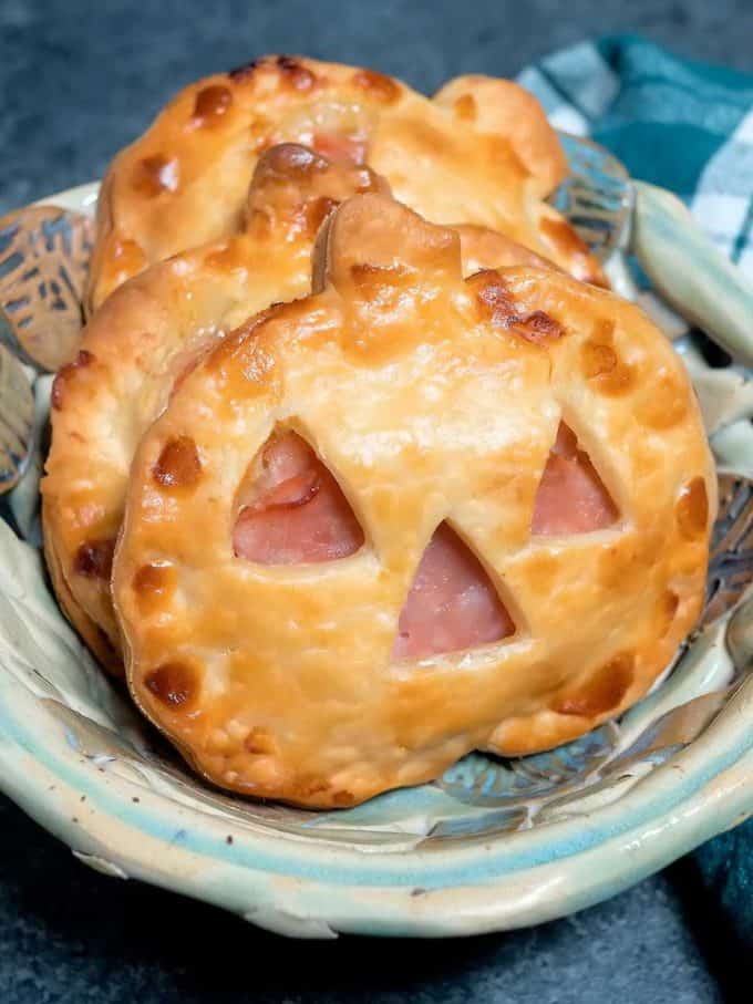 Jack o'Lantern Ham and Swiss Hand Pies made with pie dough cut into the shape of a pumpkin. 