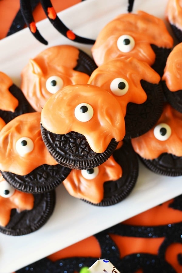 Monster Oreos with orange icing on a white plate