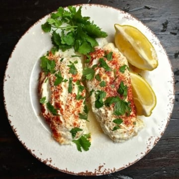Easy Baked Parmesan Grouper Fillets on a plate garnished with parsley and lemon
