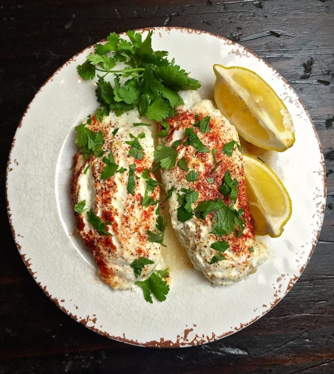 Easy Baked Parmesan Grouper Fillets on a plate garnished with parsley and lemon