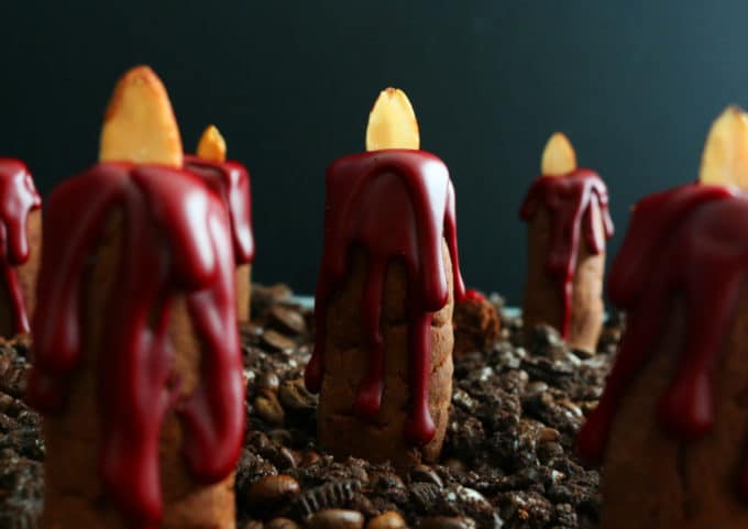 Bleeding Candle Cookies for Halloween on a bed of crushed oreos.