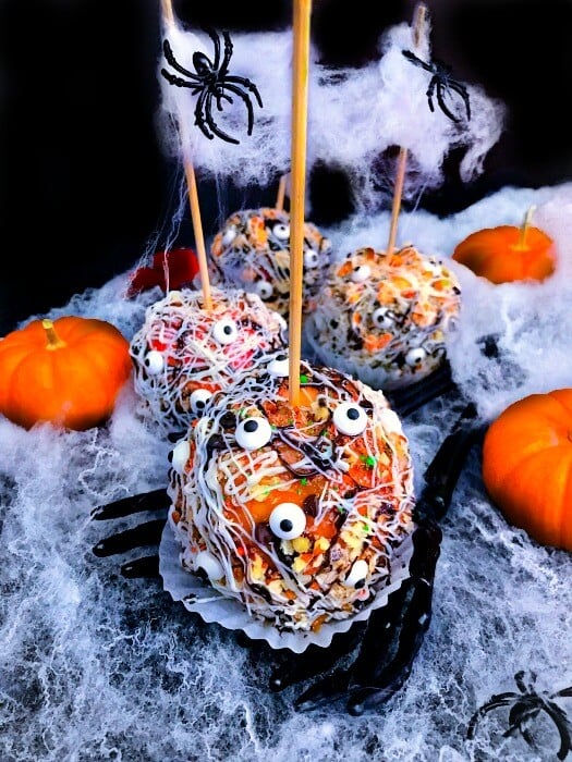 Easy Halloween Candied Apple Monsters covered in orange glaze and bits of candy. 