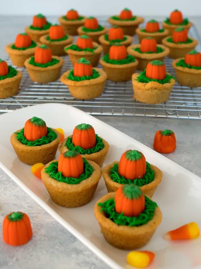 Pumpkin Patch Cookie Cups made with cookie cups stuffed with green icing and topped with a candy pumpkin. 
