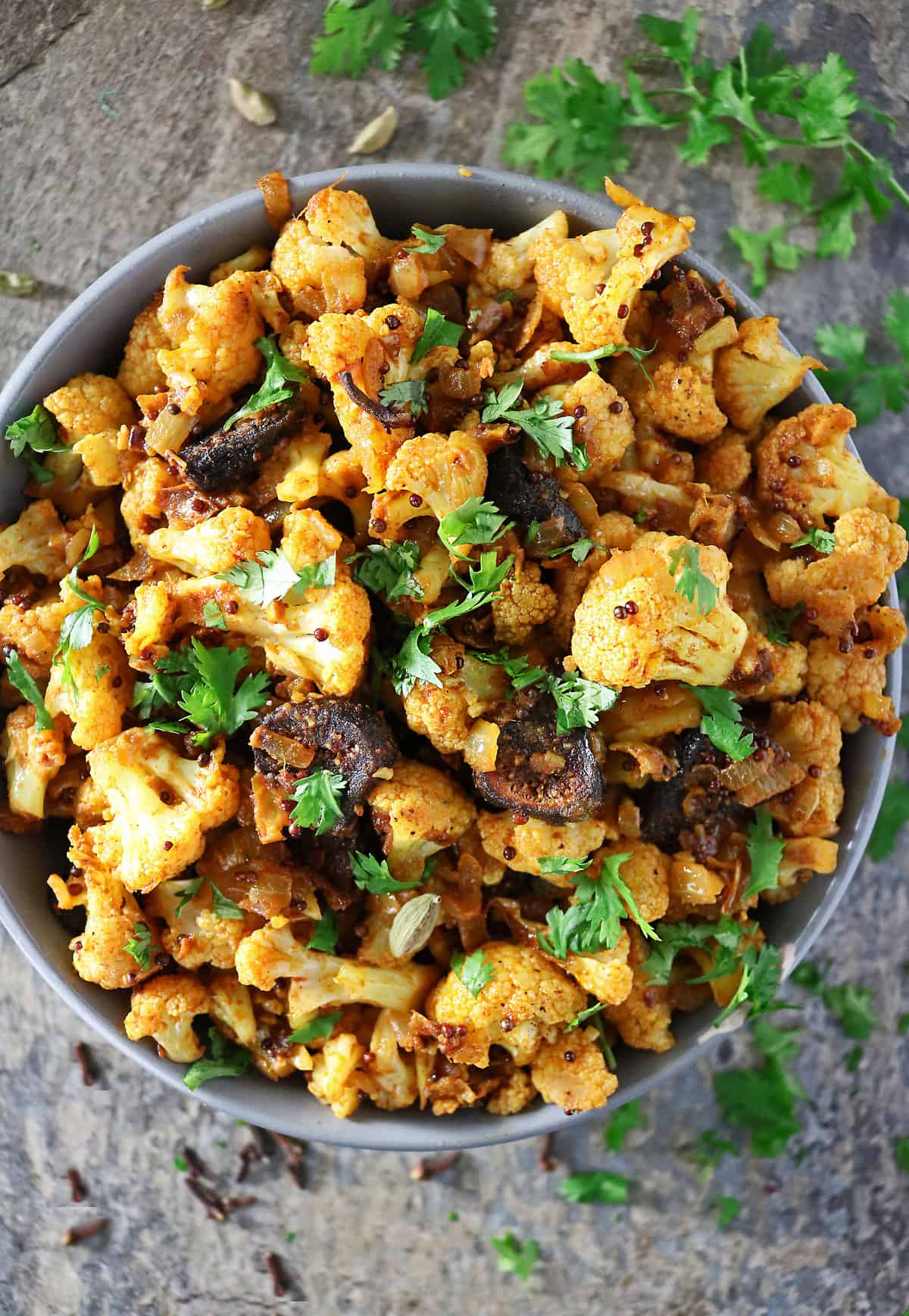 Spicy cauliflower with figs garnished with parsley in a bowl.