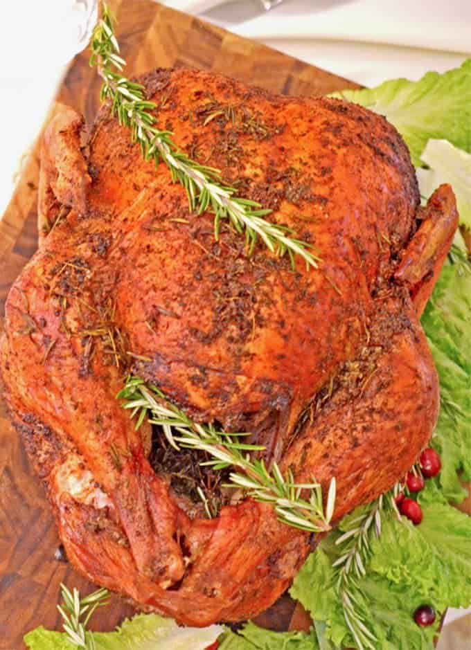 Roasted turkey with citrus and herb garnishes.