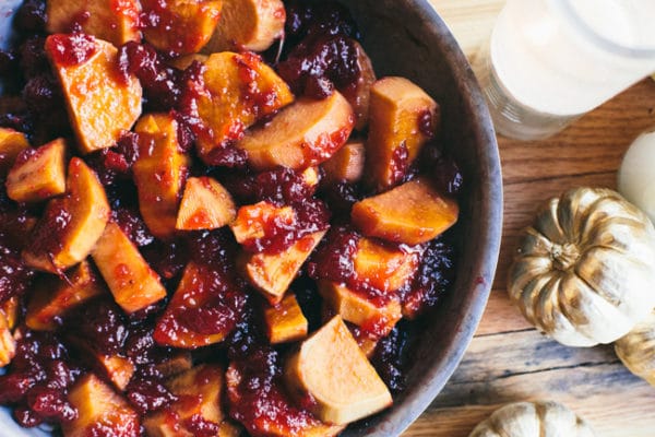 Maple Apple Cider Sweet potatoes in a bowl topped with cranberry sauce. 