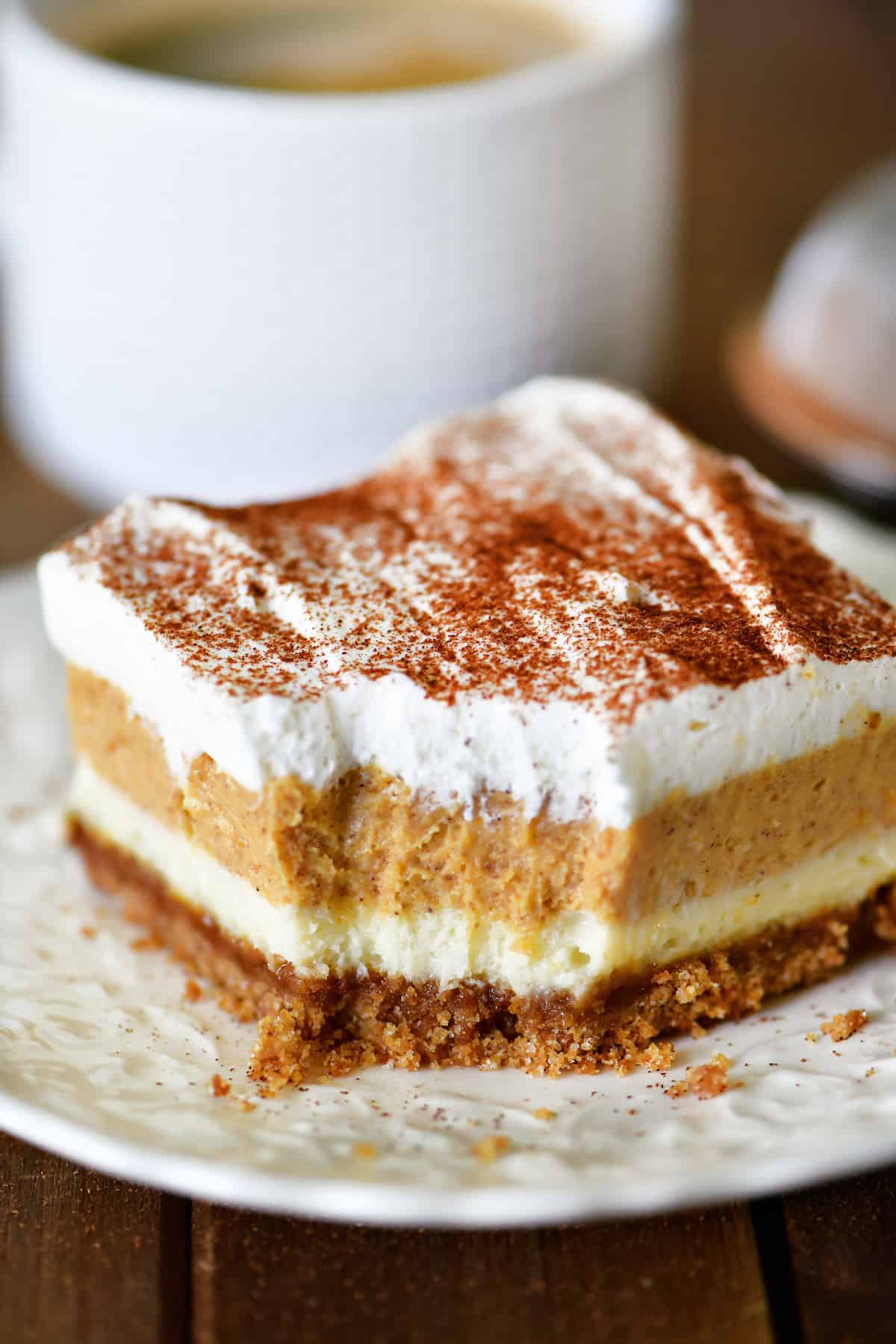 A slice of Pumpkin Cheesecake Dessert on a white plate.