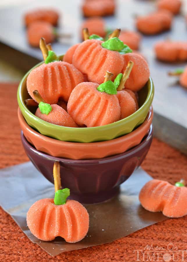 Candy shaped like a pumpkin in a green bowl.