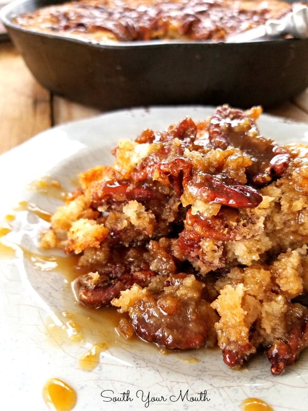 A large scoop of pecan cornbread cobbler in a white bowl.