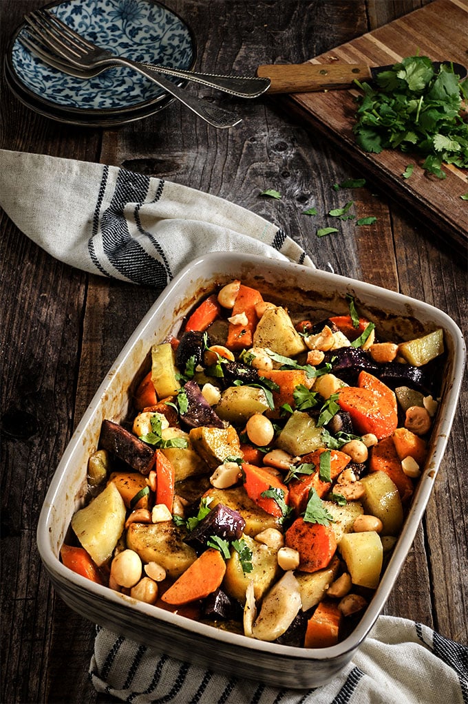 Roasted Root Vegetables in a glass baking dish on a dish towel.