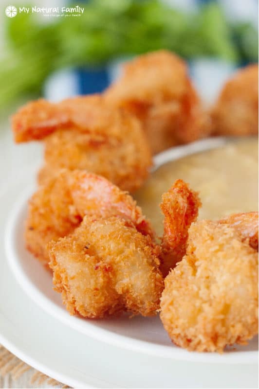 Coconut shrimp on a platter with a dipping sauce. 